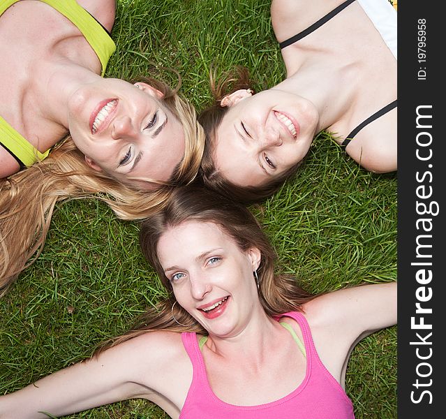 Three young girls lay on grass and express positivity. Three young girls lay on grass and express positivity