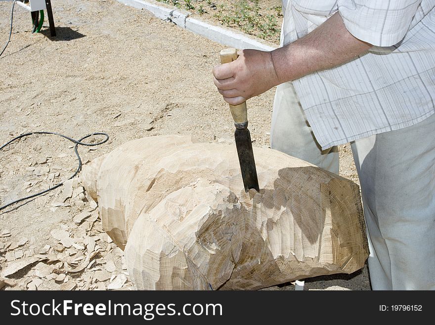 A sculptor creates a wooden sculpture