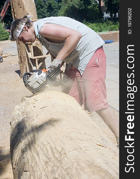 A sculptor creates a wooden sculpture