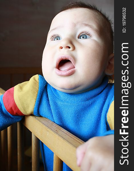 The little boy (10 months) standing on its bed and looking out of the window. The little boy (10 months) standing on its bed and looking out of the window.