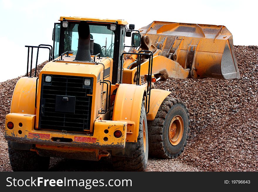 Excavator working in a quarry moving gravel