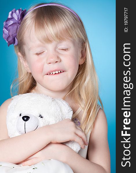 Happy dreamy little girl with toy with closed eyes