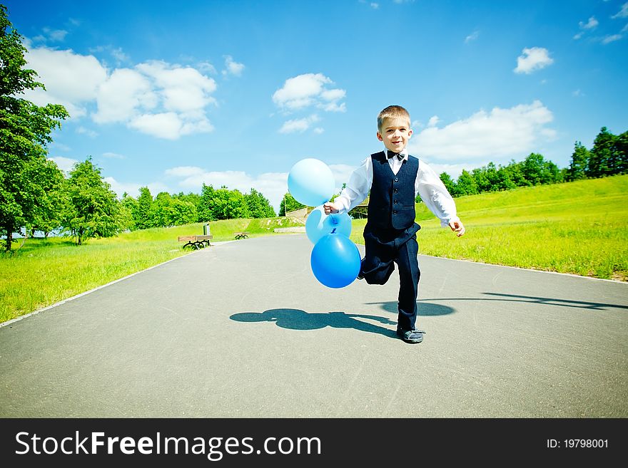Young boy moving with balloons