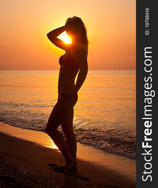 Sunrise silhouette of a woman on sea  beach