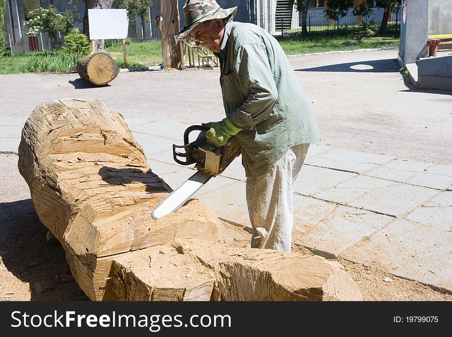 A sculptor creates a wooden sculpture