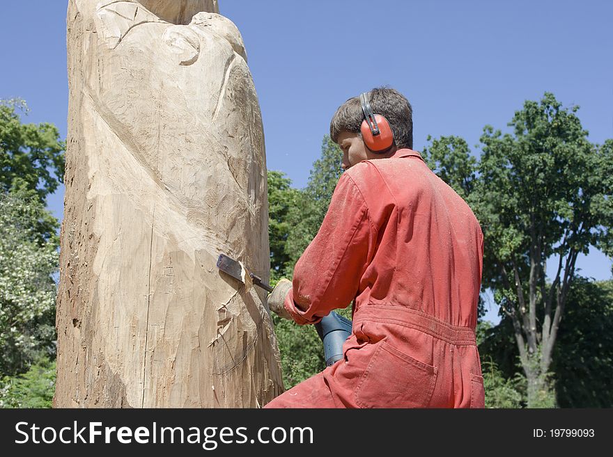 A sculptor creates a wooden sculpture