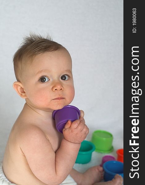 Image of adorable baby playing with stacking cups. Image of adorable baby playing with stacking cups