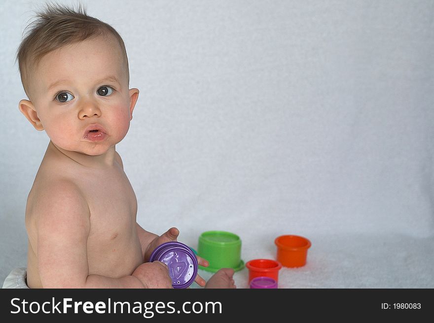 Image of adorable baby playing with stacking cups. Image of adorable baby playing with stacking cups