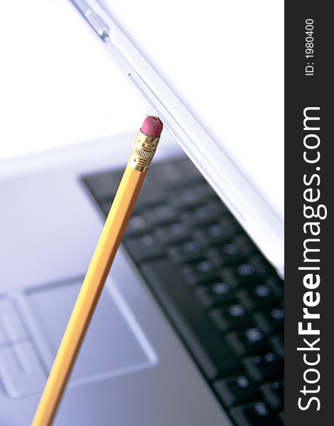 Nice blue laptop hold open by a yellow pencil isolated on a white background