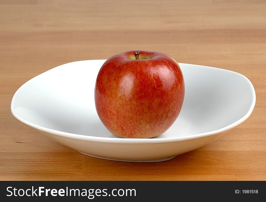 Red Fuji apple in a white bowl. Red Fuji apple in a white bowl.