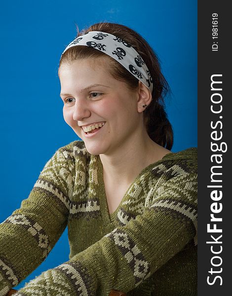 Laughing girl in the sweater against blue background. Laughing girl in the sweater against blue background