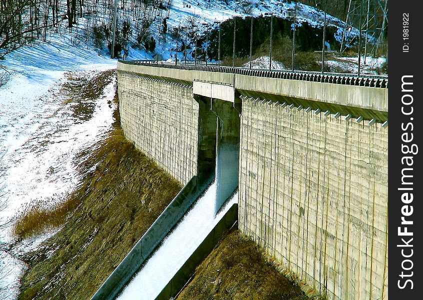 Dam in winter with water flowing