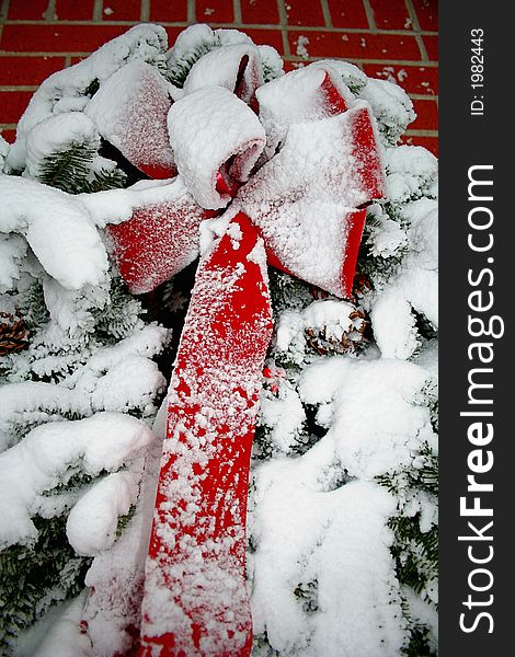 Snow covered Christmas wreath with a red bow. Snow covered Christmas wreath with a red bow