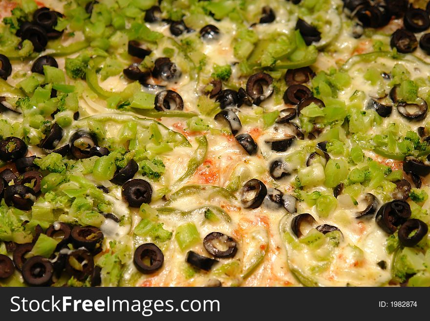 Vegetarian pizza with olives peppers and broccoli.