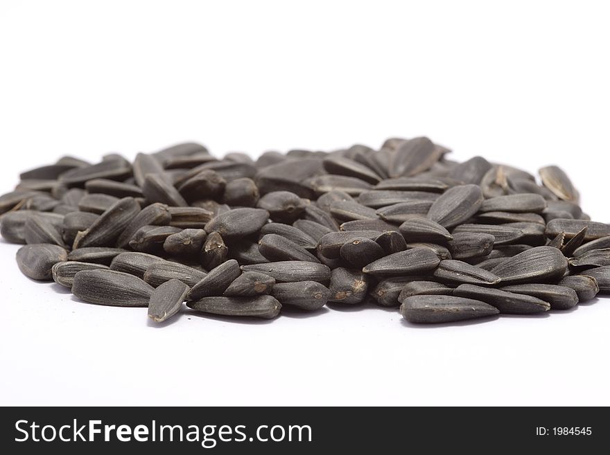 Black raw sunflower seeds on white