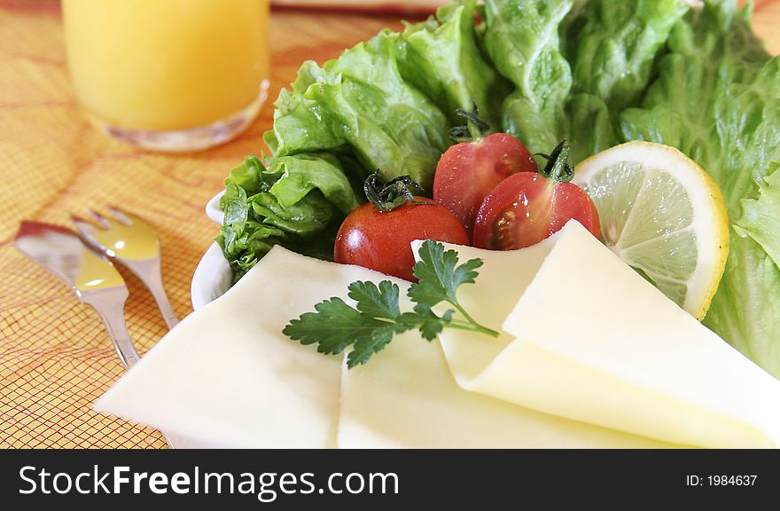 Closeup of fresh salad with cheese and lemon slice.