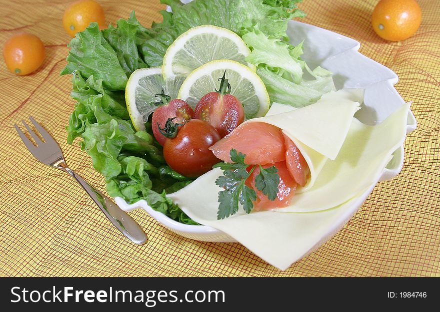 Closeup of fresh salad with cheese and lemon slice.