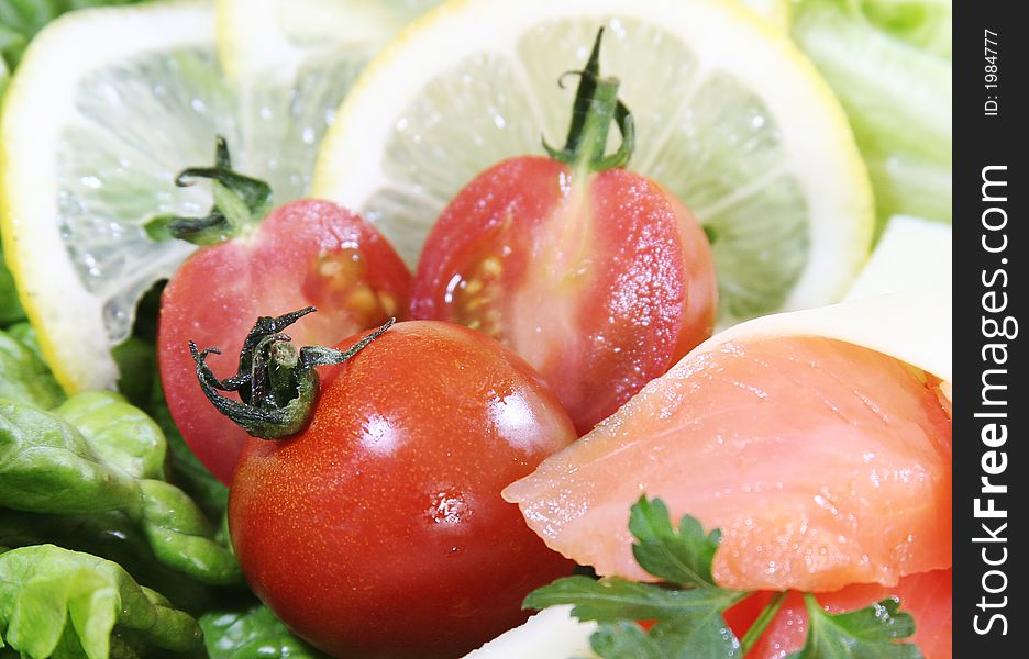 Closeup of fresh salad with cheese and lemon slice.