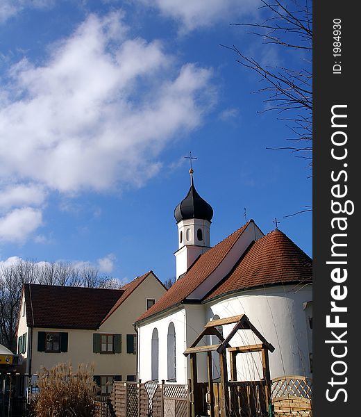 Small european church with building and blue sky. Small european church with building and blue sky