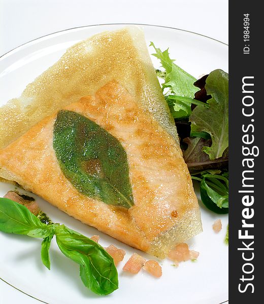 Fillet of salmon fried in phillo pastry with a basil leaf, salad and pesto sauce. Fillet of salmon fried in phillo pastry with a basil leaf, salad and pesto sauce