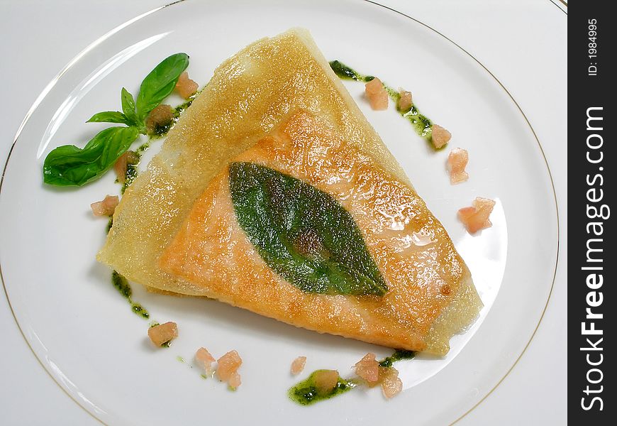 Fillet of salmon fried in phillo pastry with a basil leaf and pesto sauce. Fillet of salmon fried in phillo pastry with a basil leaf and pesto sauce