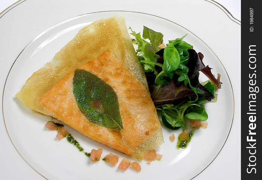 Fillet of salmon fried in phillo pastry with a basil leaf, salad and pesto sauce. Fillet of salmon fried in phillo pastry with a basil leaf, salad and pesto sauce