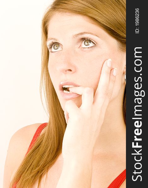 A young woman deep in thought against a plain background.