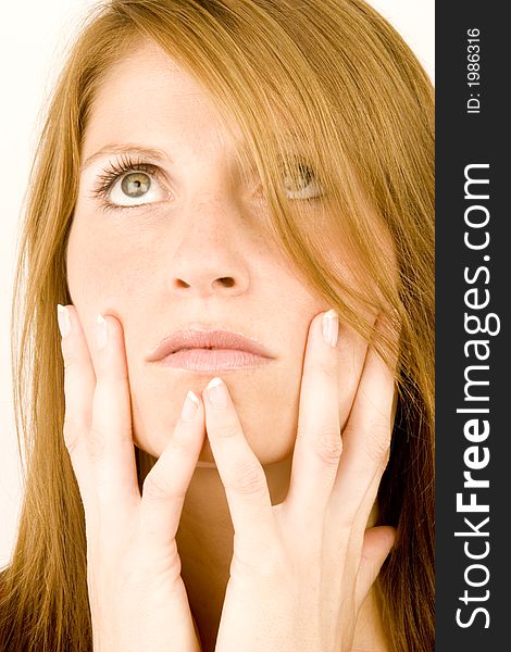 A young woman deep in thought against a plain background.