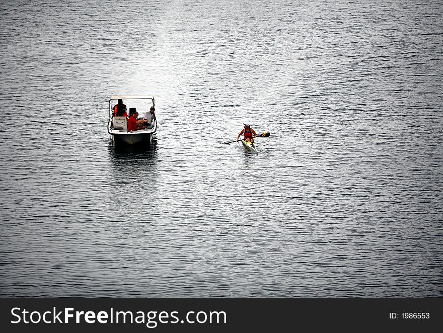 An alone man kayaking on a lake.