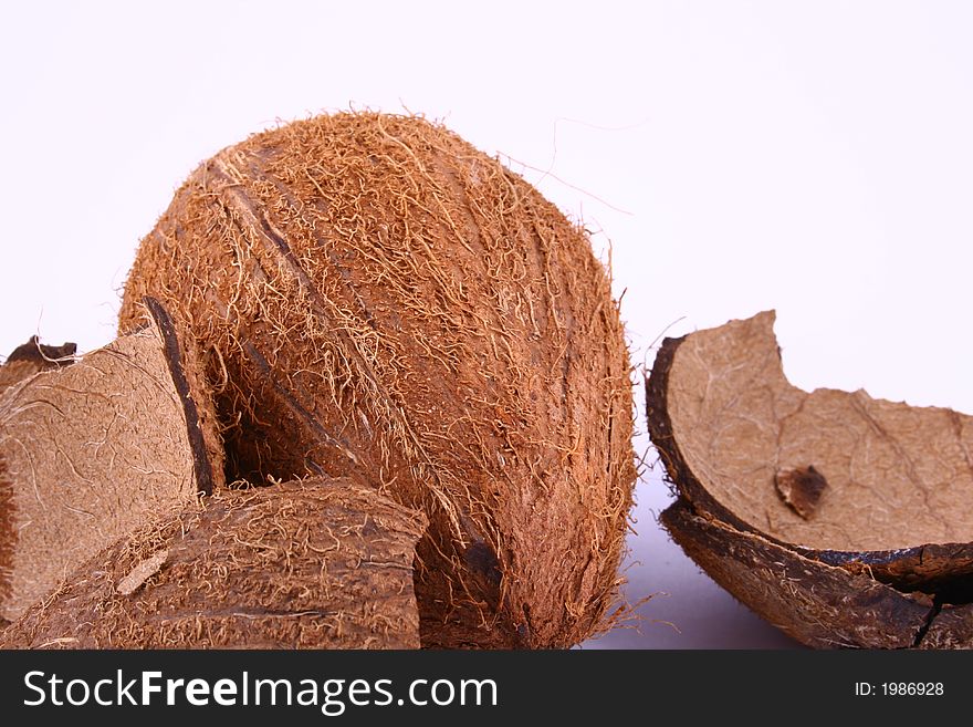 Whole and broken coconut on white background