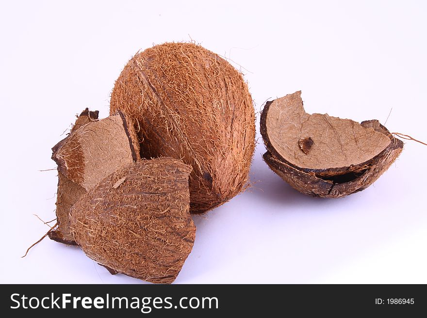 Whole and broken coconut on white background