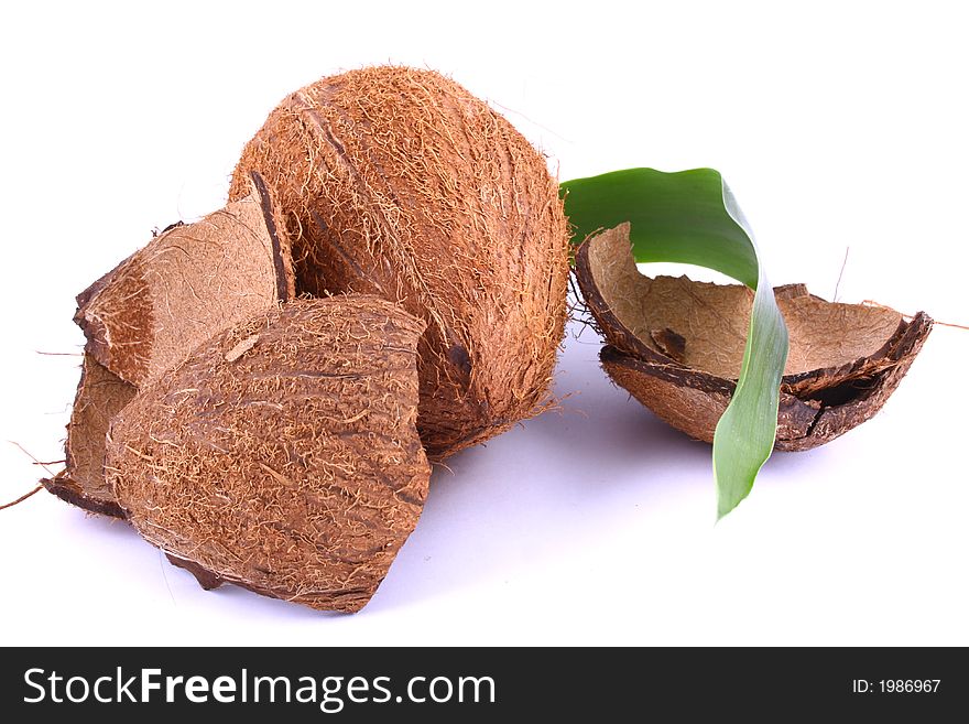 Whole and broken coconut on white background