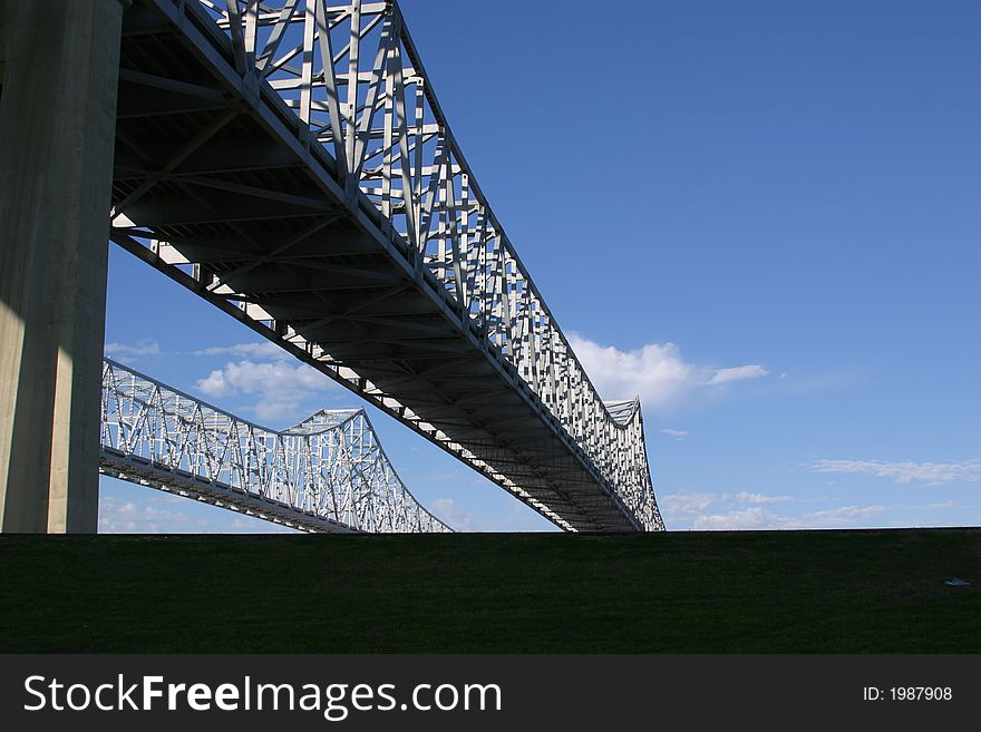 View of the Crescent City COnnection bridges as they rise above a levee in New Orleans.