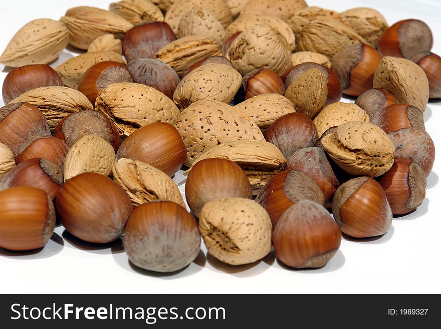 Hazelnuts and almonds on a white background