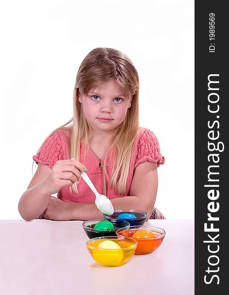 Young girl coloring easter eggs shot over white.