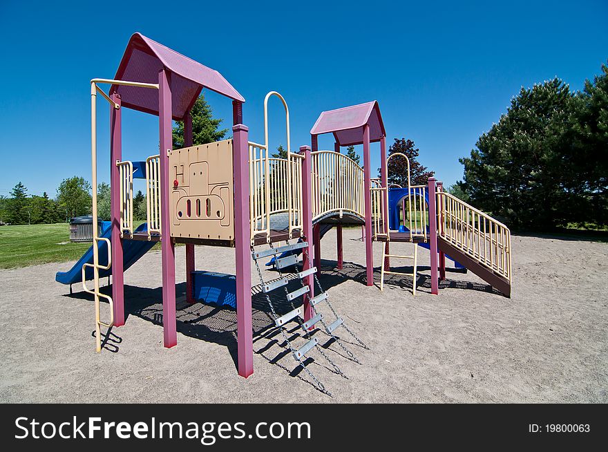 A small neighborhood park with brightly colored playground equipment. A small neighborhood park with brightly colored playground equipment.