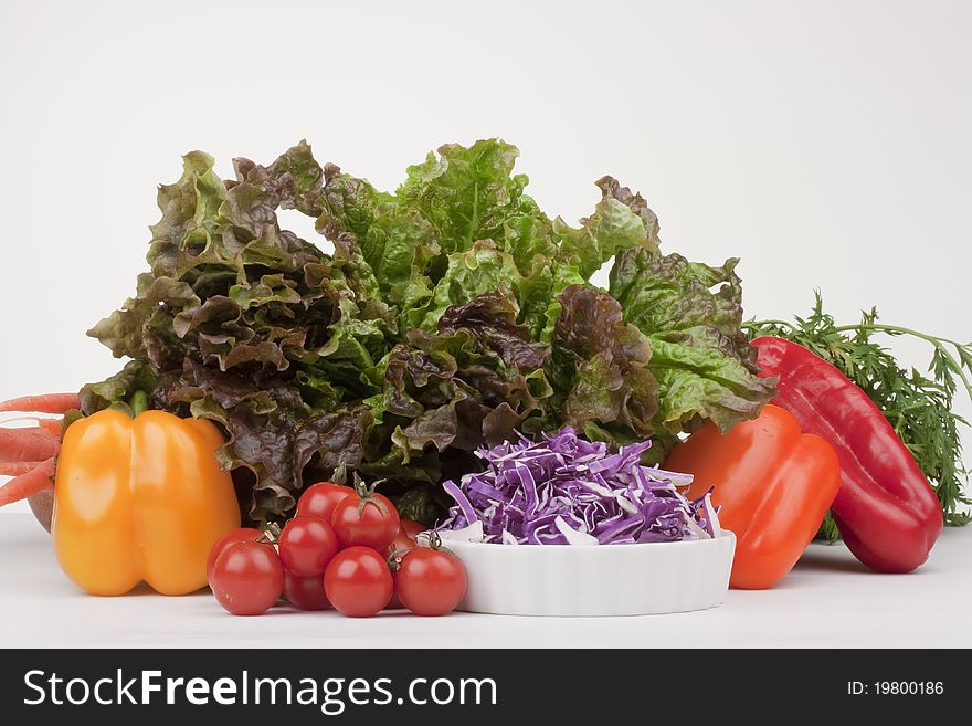 Vegetable ingredients for making salad: lettuce, red cabbage, tomatoes, peppers.