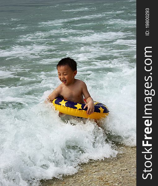 An Asian boy is playing in wave,he is at magical moments. An Asian boy is playing in wave,he is at magical moments