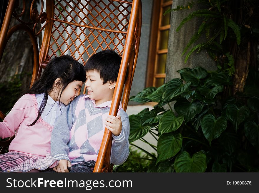 A couple of children playing on the rocking chair