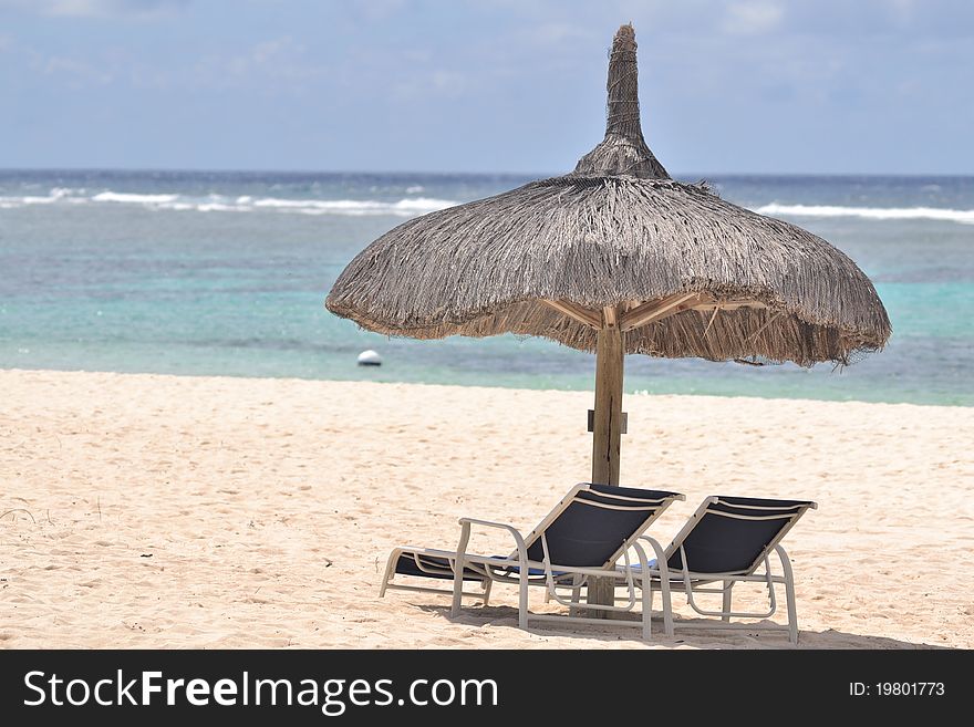 Grass hut or umbrella on beach with chairs. Grass hut or umbrella on beach with chairs