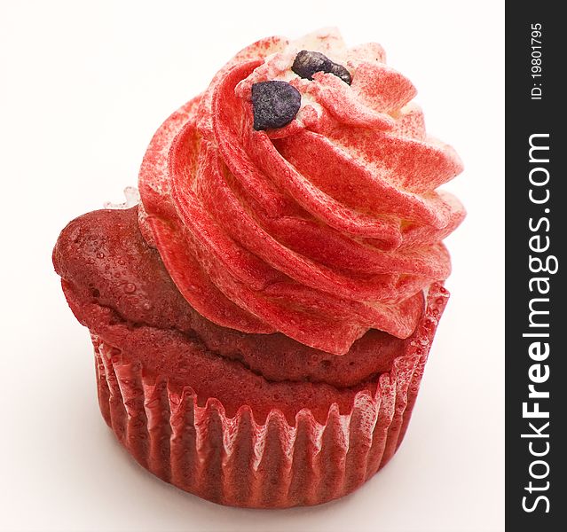 Red velvet cupcake decorated with red colored buttercream frosting against a white background.
