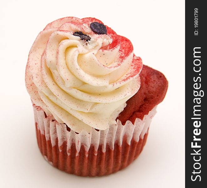 Red velvet cupcake decorated with red colored buttercream frosting against a white background.