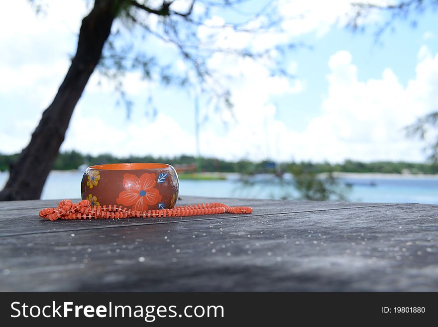 Orange and brown arm bracelet and beads on a table