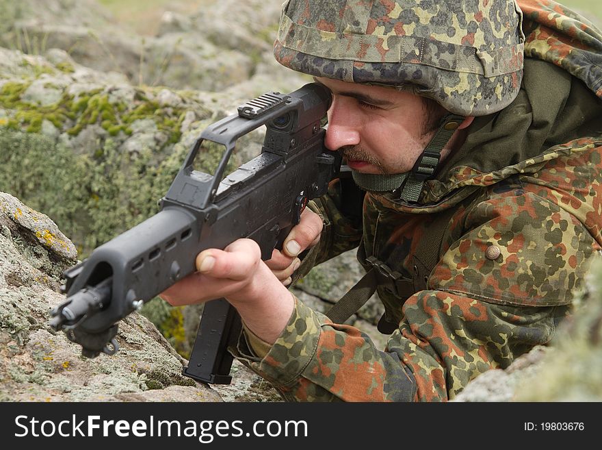 Warrior hiding behind the rock with a gun. Warrior hiding behind the rock with a gun