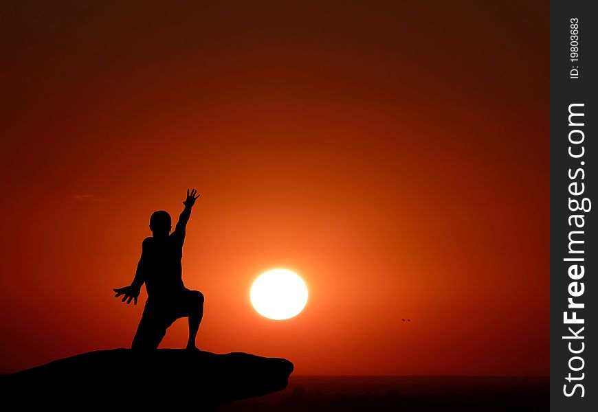 Silhouette of a man at the top of the mountain against the sky