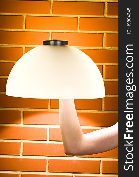 Lampshade mounted on the arm against brick wall. Lampshade mounted on the arm against brick wall