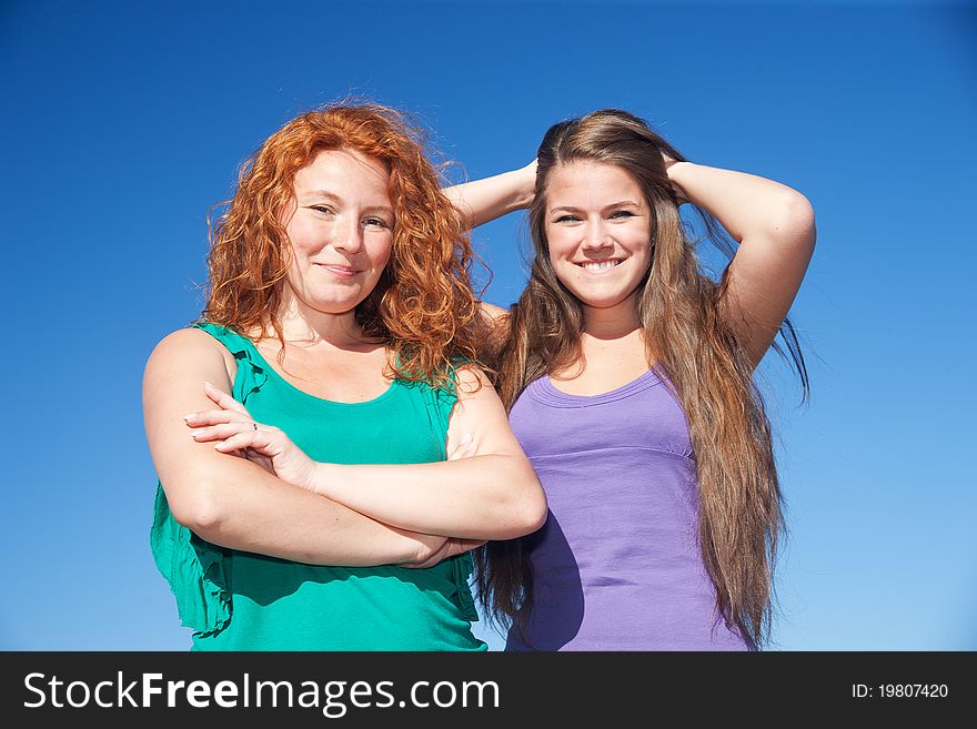 Two women have fun on top of hill in park. Two women have fun on top of hill in park