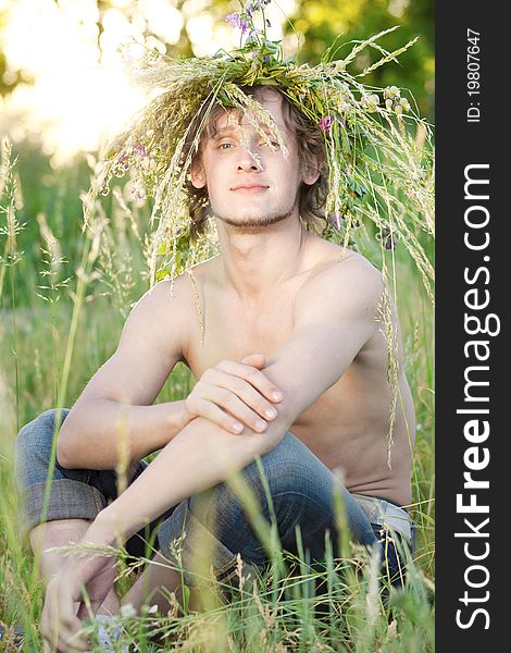 Portrait of young man that sit on grass in park. Portrait of young man that sit on grass in park