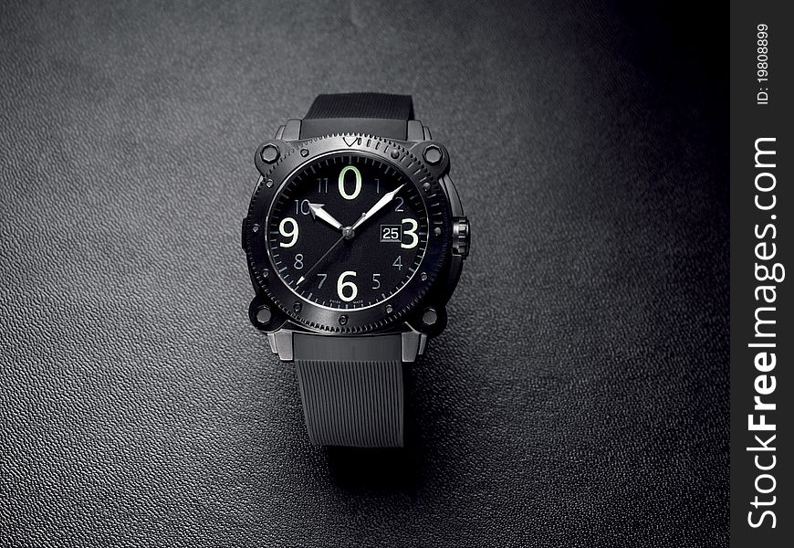 Stylish contemporary wrist watch on a textured black background