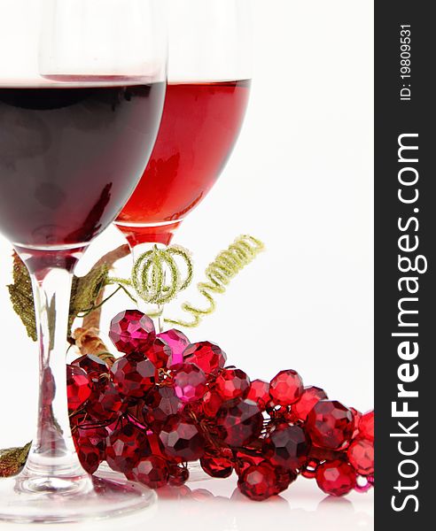 Red wine in glasses with shiny stone grape branch